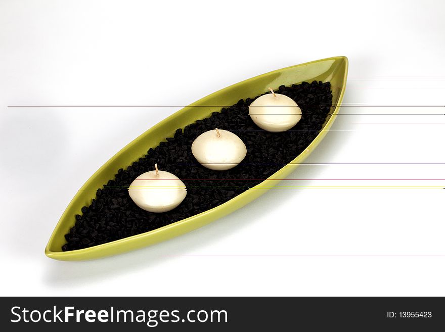 Candle boat with three candles and black pebbles in it. Candle boat with three candles and black pebbles in it.