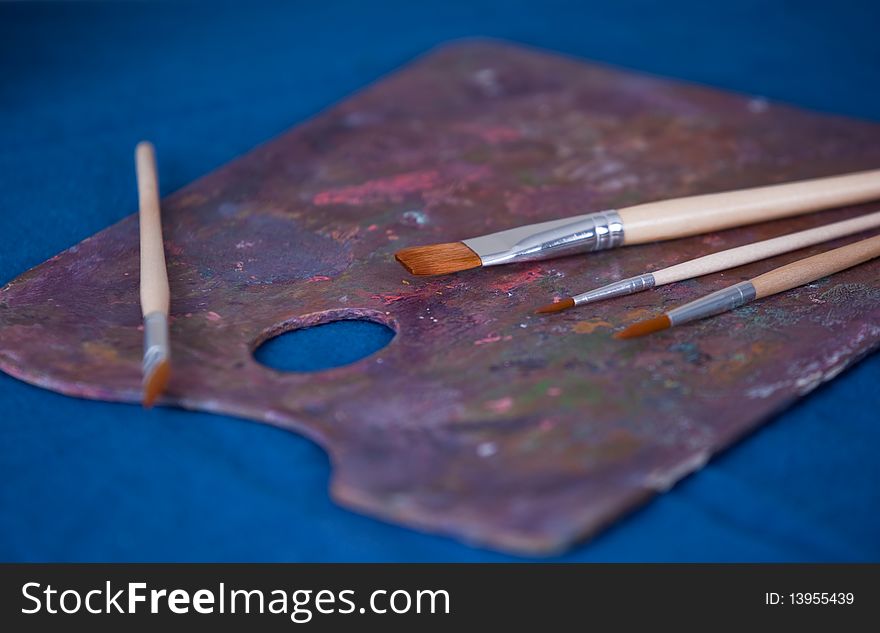 Paint palette and brushes on blue background. Paint palette and brushes on blue background