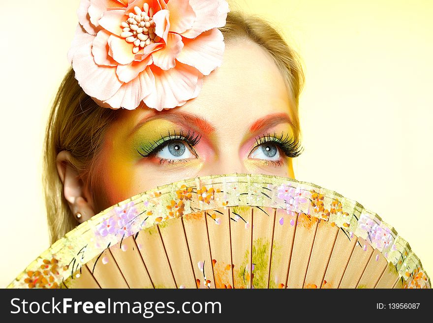 Close-up portrait of summer fashion creative eye make-up in yellow and green tones. Close-up portrait of summer fashion creative eye make-up in yellow and green tones