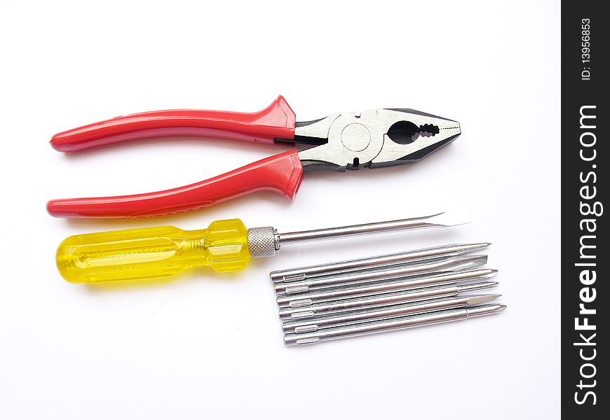 Red plier and yellow screw driver set isolated on white. Red plier and yellow screw driver set isolated on white.