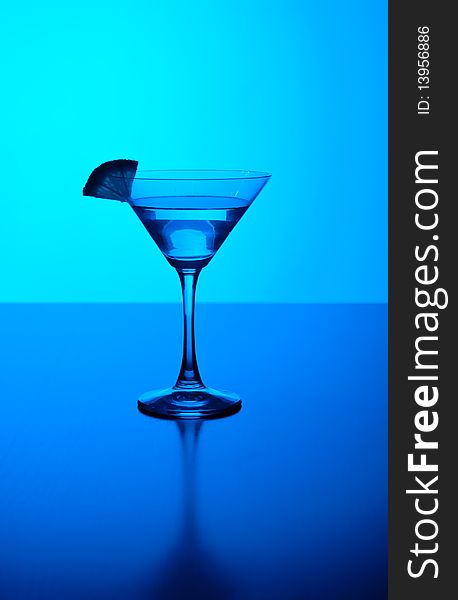 Cocktail glass with blue lit backgrpound. Cocktail glass with blue lit backgrpound