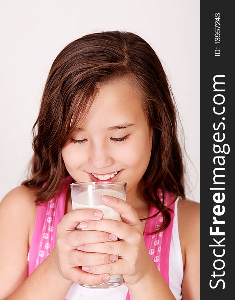 Happy girl drinking milk over white background. ten years old