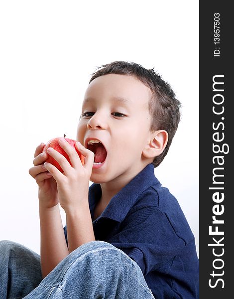 Child eating apple over white background. Healthy food