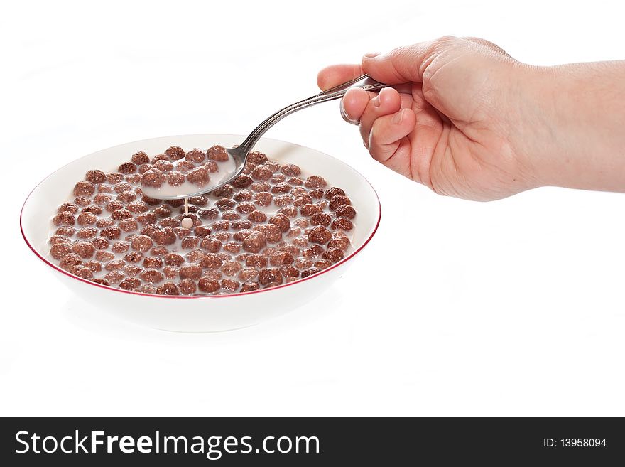 Hand serving a portion of chocolate cereal on a white background