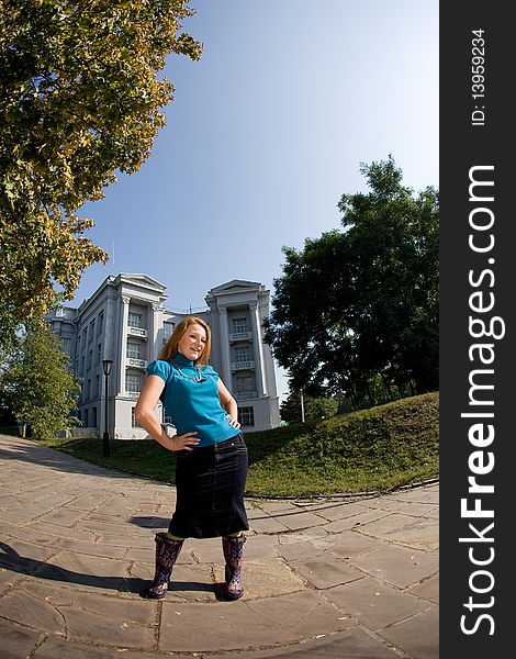 Portrait of positive red hair woman in garden opposite big house