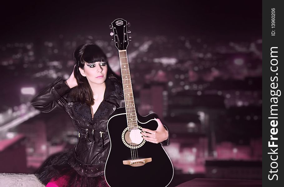 The young girl with a guitar on a roof of a high-rise building. The young girl with a guitar on a roof of a high-rise building