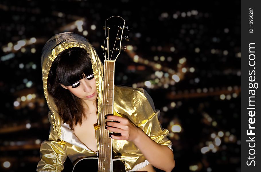 The young girl with a guitar on a roof of a high-rise building. The young girl with a guitar on a roof of a high-rise building