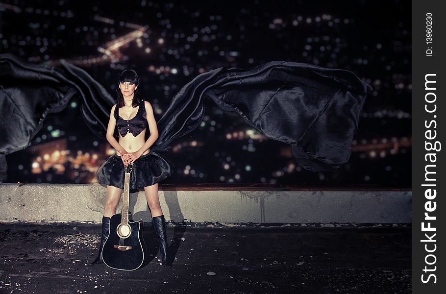 young girl with a guitar on a roof of a high-rise building. young girl with a guitar on a roof of a high-rise building