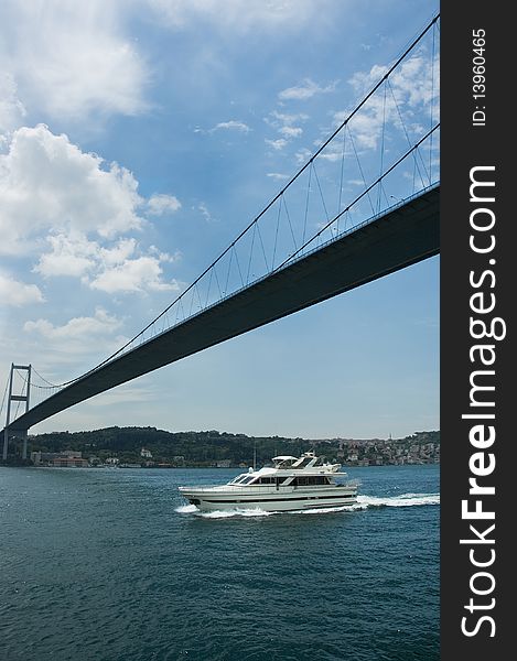 Small motorboat cruising under the bridge over Bosphorus. Small motorboat cruising under the bridge over Bosphorus