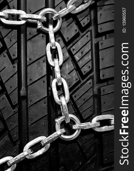 Backgorund of a black rubber tyre with chain. Backgorund of a black rubber tyre with chain