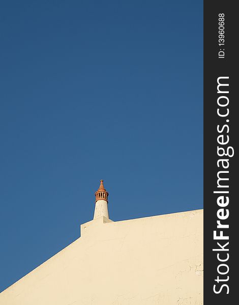 Typical algarvian chimney with a blue sky in the background.