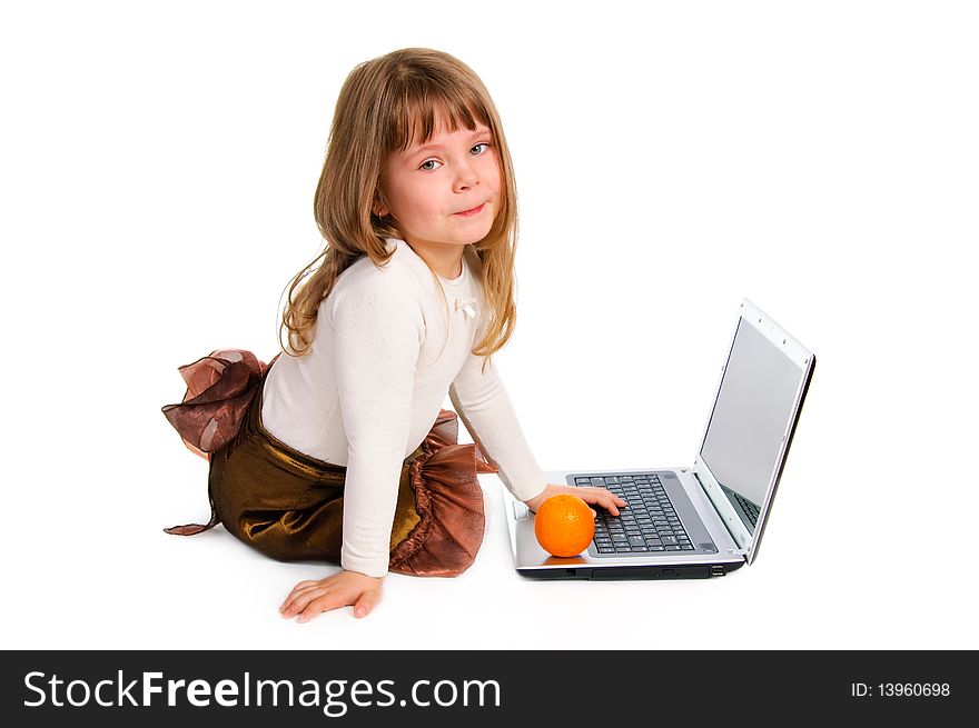 Sitting little girl with the laptop and fresh orange. White background. Sitting little girl with the laptop and fresh orange. White background.