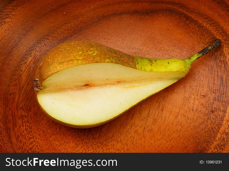 Pear on a wooden plate