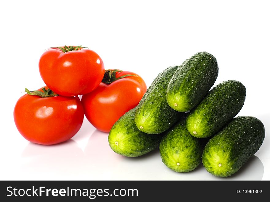 Tomatoes and cucumbers heaps isolated on white background