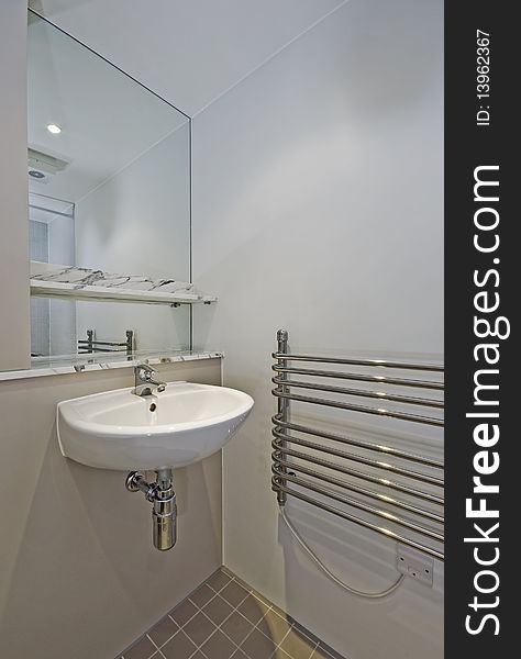 White ceramic hand wash basin and electric towel rail