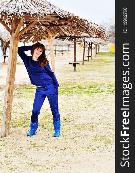 Redheaded girl spending her free time on the beach in spring time