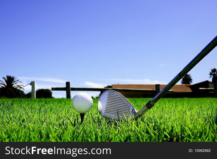 Ball and golf clubs on the bright green grass - as a symbol of success