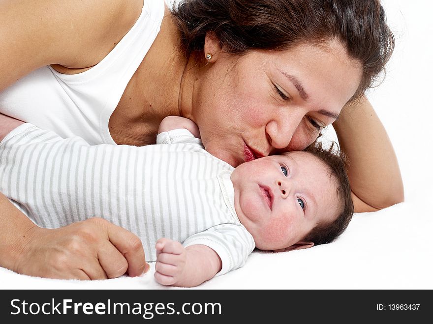 Mother And Baby Lying On The Bed And Playing