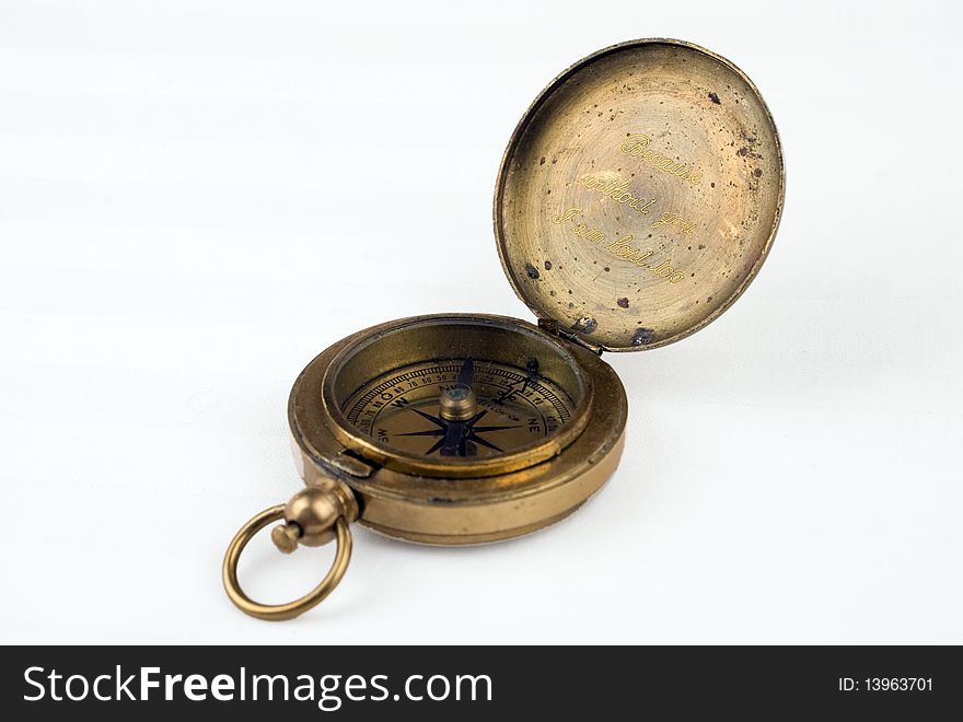 Image of a brass compass opened and showing the engraving.