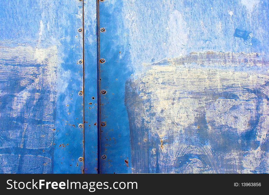 Detail of the old iron door painted in blue.