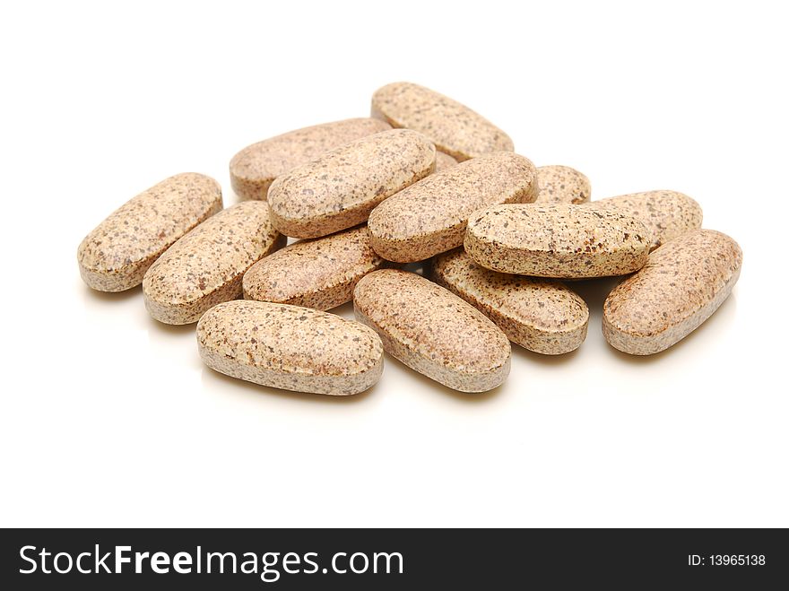 A pile of vitamin supplement tablets on white. A pile of vitamin supplement tablets on white