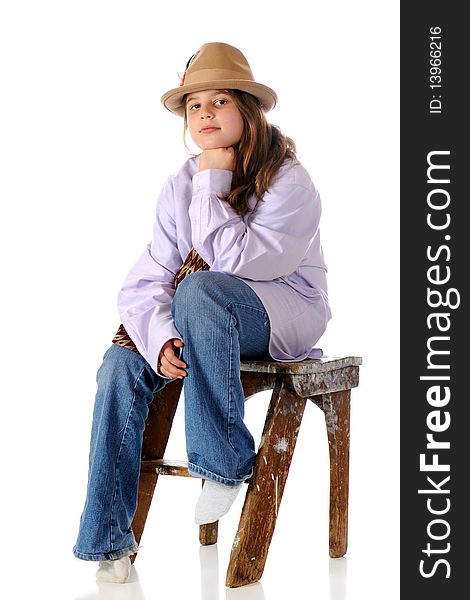 A serious preteen girl sitting on a battered step-stool wearing grandpa's clothes. Isolated on white. A serious preteen girl sitting on a battered step-stool wearing grandpa's clothes. Isolated on white.