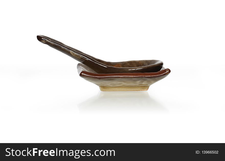 Ceramic spoon on plate. Isolated on white with clipping path