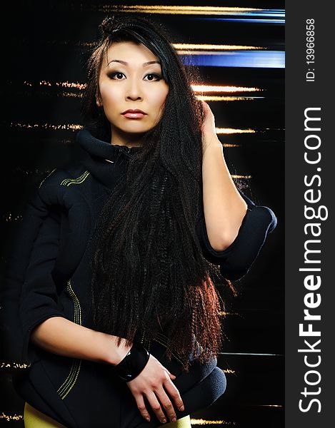 Brunette asian model on black background with night lights