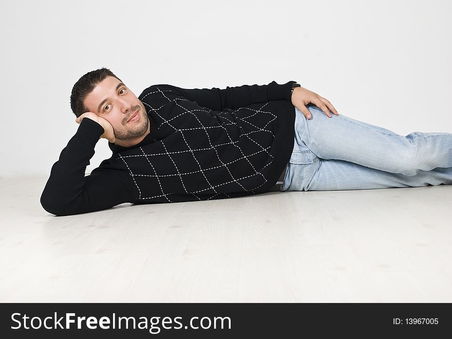 Cool man lying down on white wooden floor and wearing a black pullover and jeans,see more in. Cool man lying down on white wooden floor and wearing a black pullover and jeans,see more in