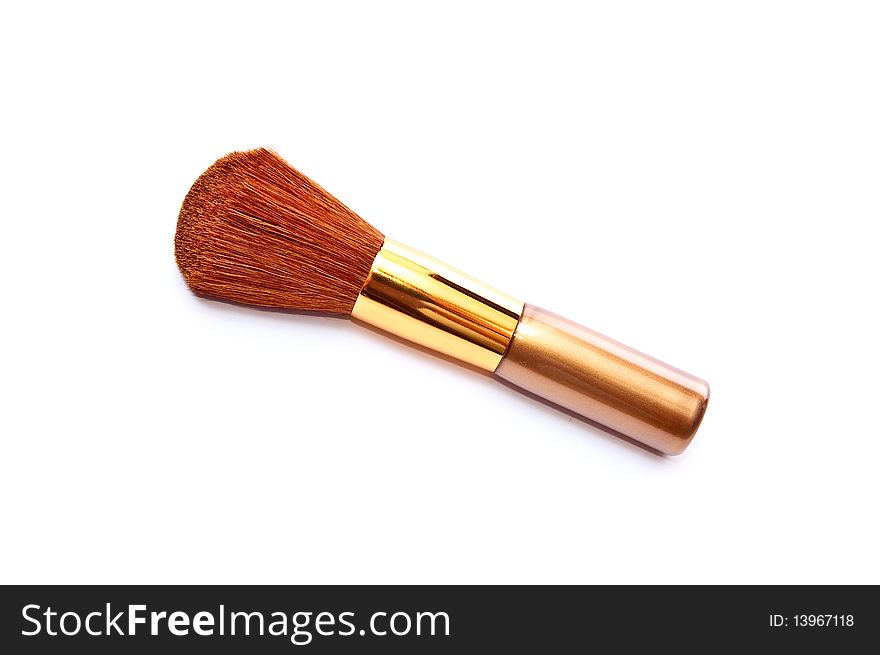 Gold metal makeup brush isolated on white