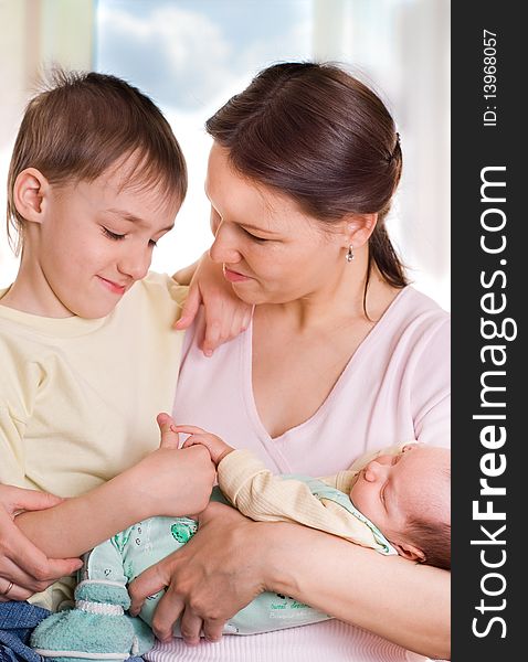 Young mother sits with her two children. Young mother sits with her two children