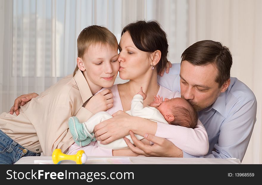 Happy young parents kissed his two children