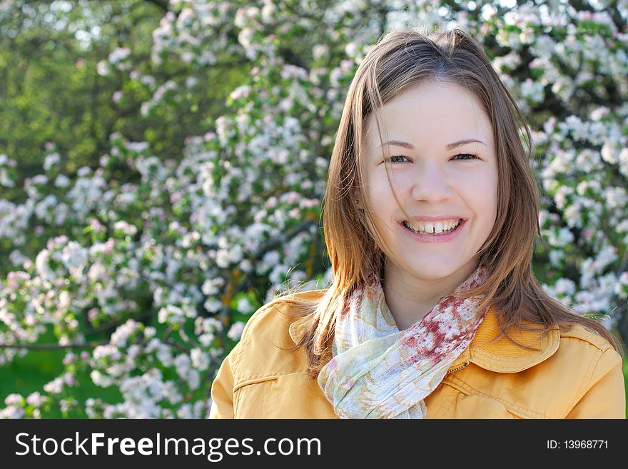 Young woman posing with a blooming branch in a spring park. Young woman posing with a blooming branch in a spring park