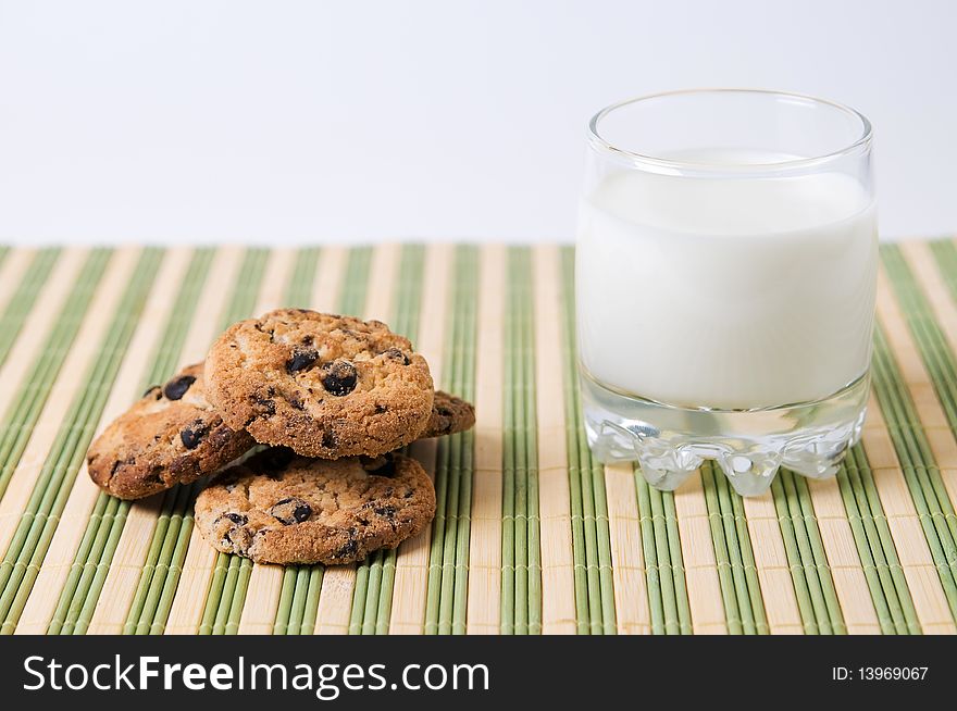 Glass of milk and chocolate cookies on stripe surface. Glass of milk and chocolate cookies on stripe surface