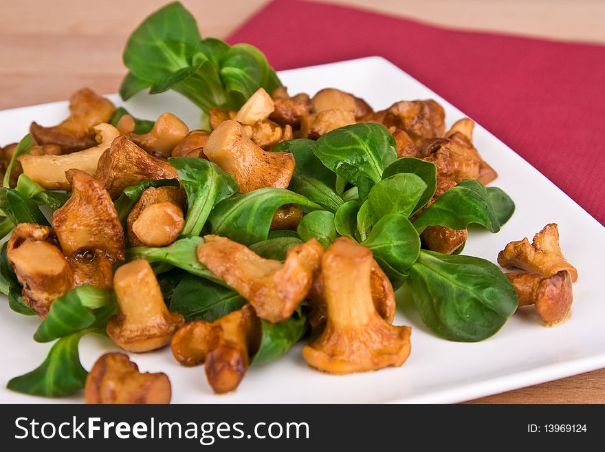 Chanterelles with salad on a plate
