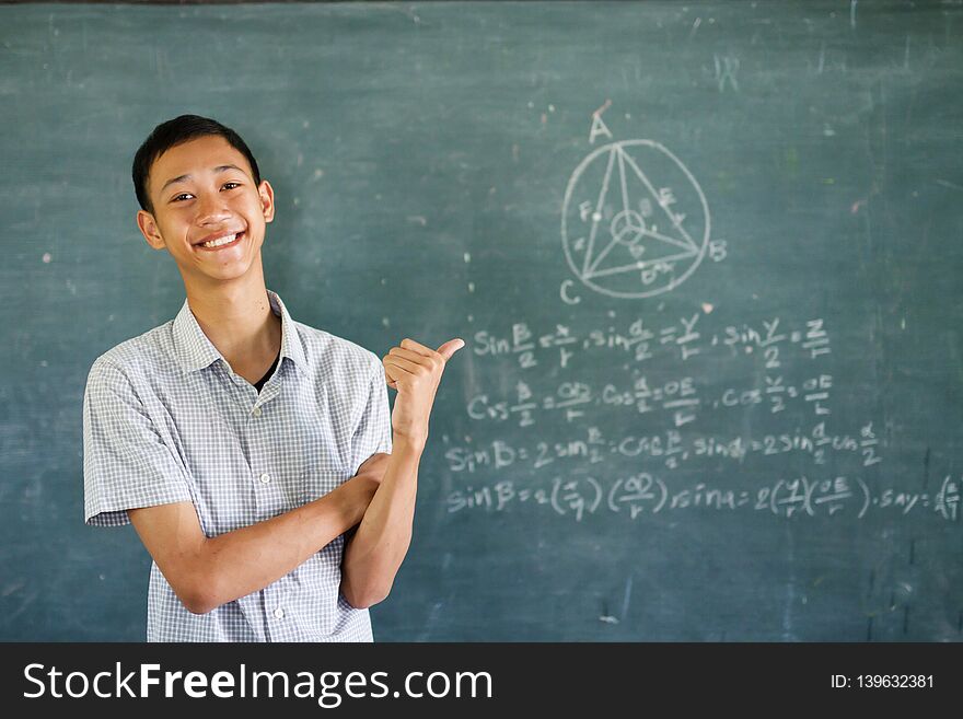 Smart Asian student solve the Math in classroom with smile face. Education concept. Smart Asian student solve the Math in classroom with smile face. Education concept.