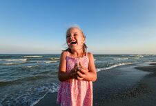Little Pretty Girl On Summer Beach. Cheerful Little Girl Laughs On The Background Of Blue Sky And Summer Sea Stock Image