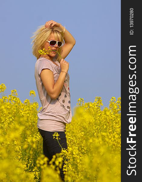 Blonde Girl with Sunglasses in the Flower Field to blue Sky. Blonde Girl with Sunglasses in the Flower Field to blue Sky