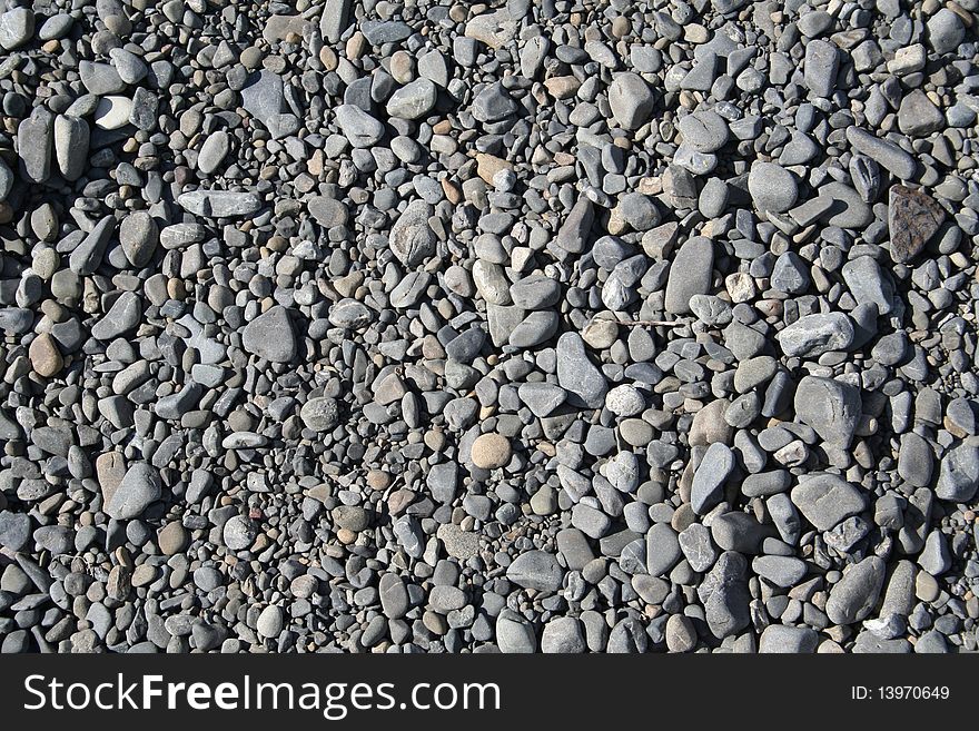 A patch of smooth black river stones