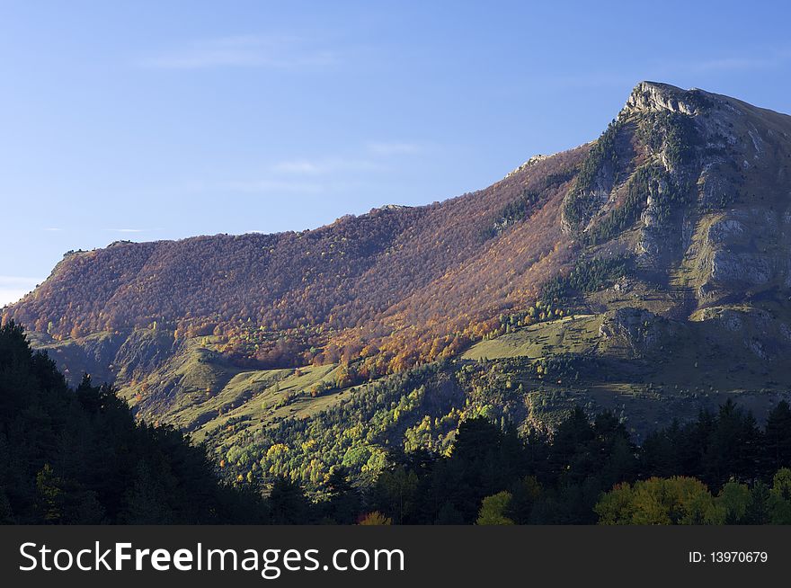 Autumnal forest and rocky peak in the Pyrenees, Spain