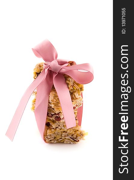 Muesli bar with pink bow on a white background