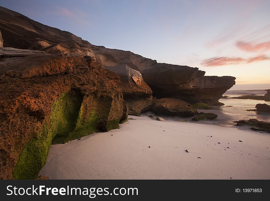 Image of a rock with moss on at a beach in South Africa. Image of a rock with moss on at a beach in South Africa