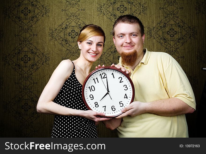 An image of a man and a woman with a clock. An image of a man and a woman with a clock