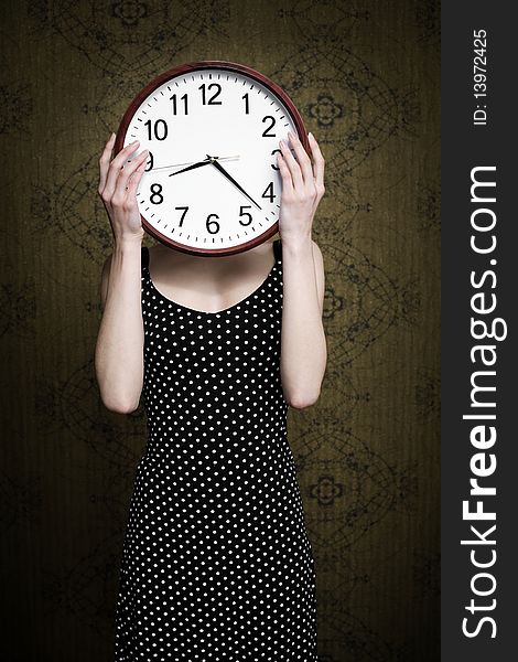 An image of a girl holding a big white clock. An image of a girl holding a big white clock