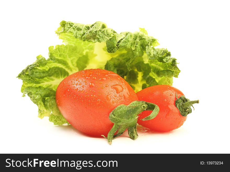 Tomato with drops of water and leaf of cabbage isolated on white background. Tomato with drops of water and leaf of cabbage isolated on white background