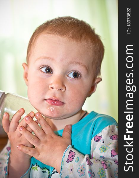 Young baby boy with bottle of juice