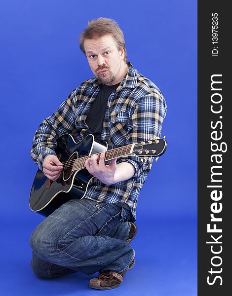 Studio portrait of man playing acoustic guitar. Studio portrait of man playing acoustic guitar