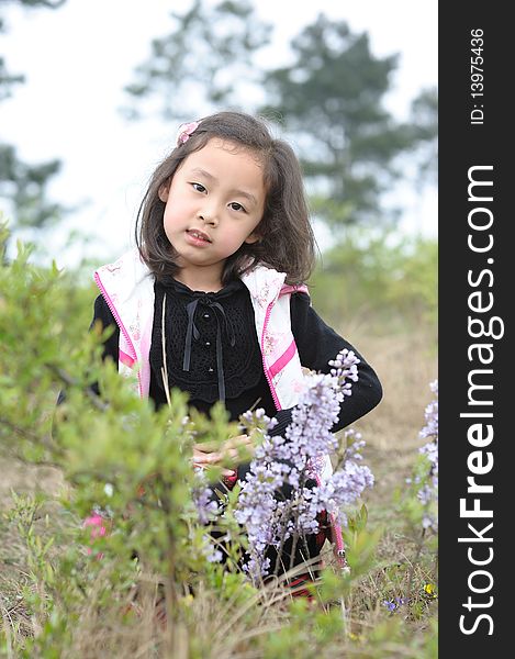 Lovely little asian girl in flowers.