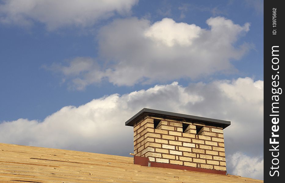 Yellow brick chimney against a cloudy sky