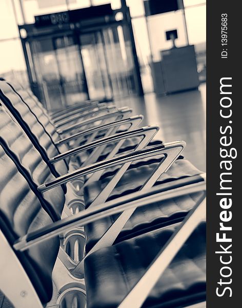 Empty chairs at the airport, entrance in the background. Empty chairs at the airport, entrance in the background